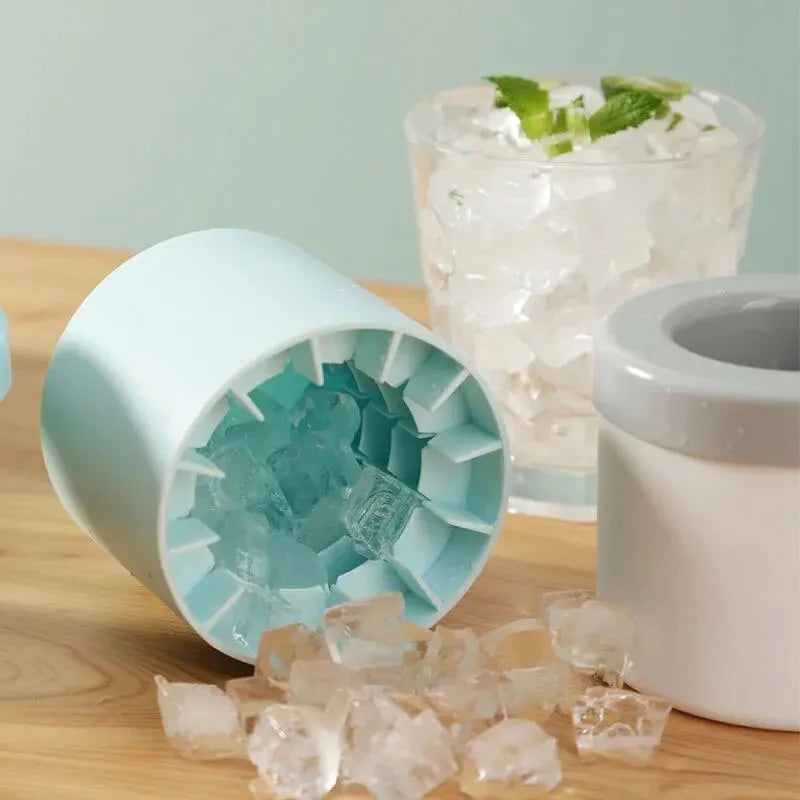 Ice cube tray with ice cubes next to a glass of water on a wooden surface.