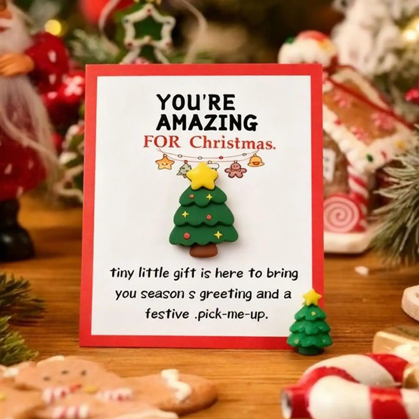 Christmas card with a small green Christmas tree decoration on a festive background.