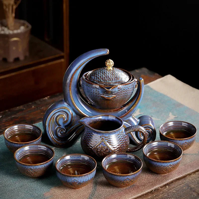 Ceramic teapot set with multiple cups on a textured surface