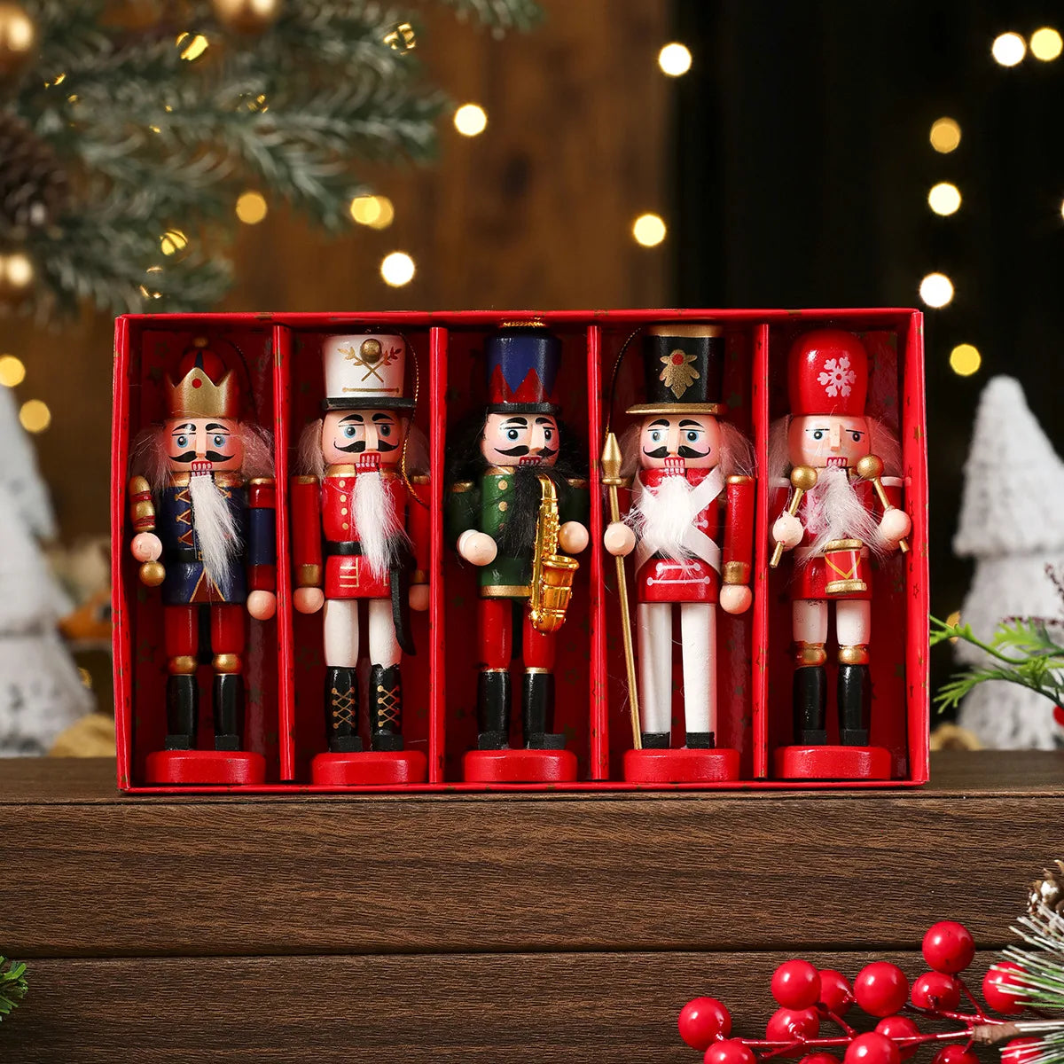 Set of five nutcracker figurines in a red box with Christmas decorations in the background.