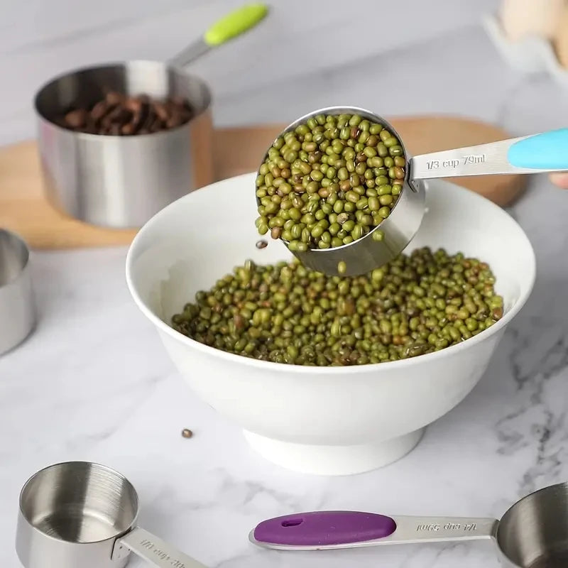 Measuring cup filled with green beans being poured into a white bowl on a marble surface.