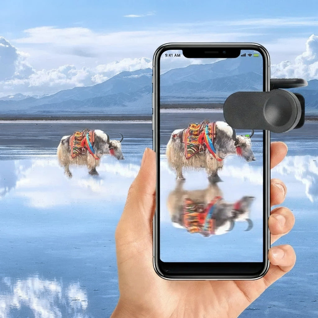 Hand holding a smartphone with a scenic app open, showing two decorated yaks on a lake with mountains in the background.