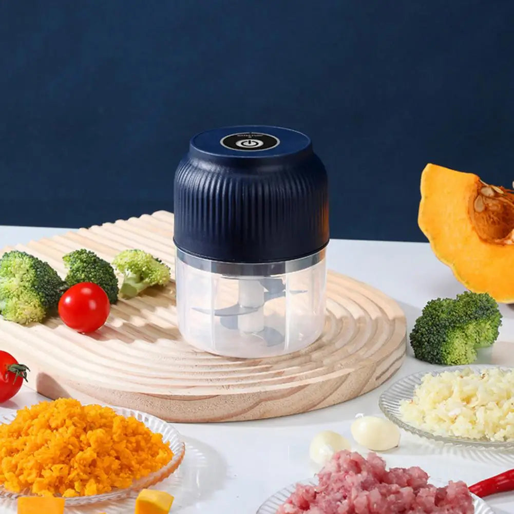 Blue food chopper on a wooden board with vegetables and processed foods around it.