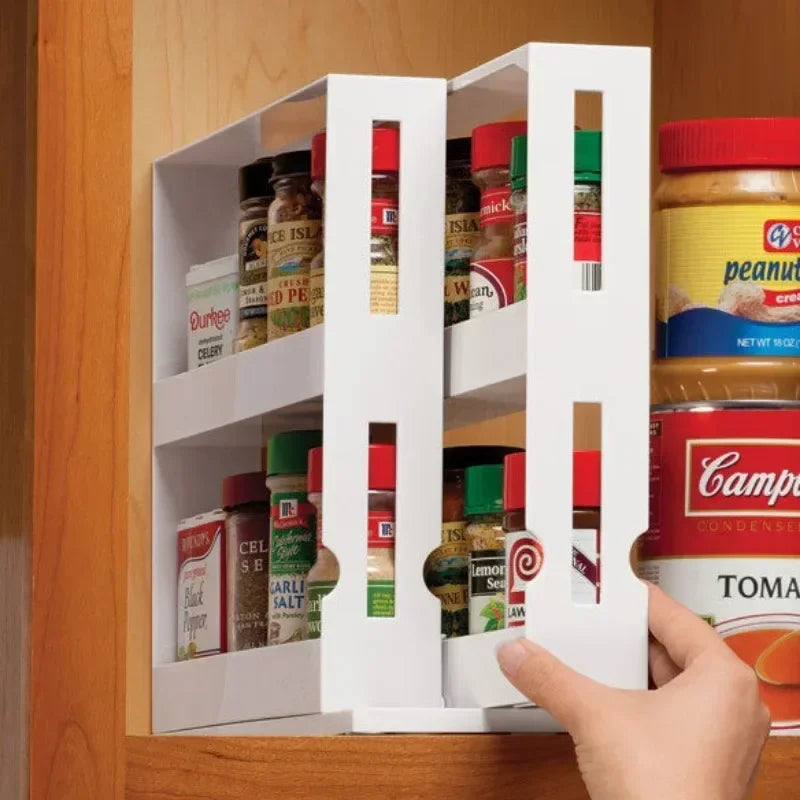 White pull-out spice rack being used to organize spices in a kitchen cabinet.