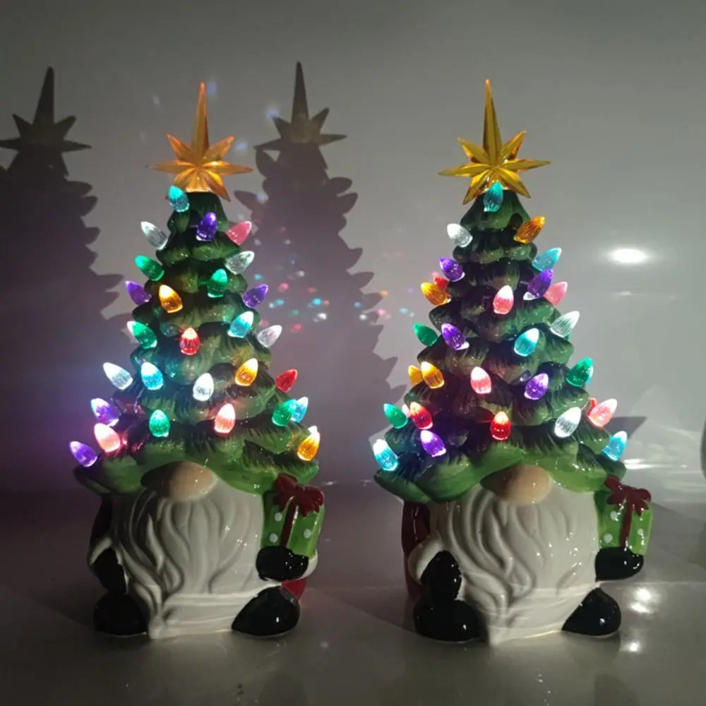 Two decorative Christmas trees with colorful lights on a reflective surface.