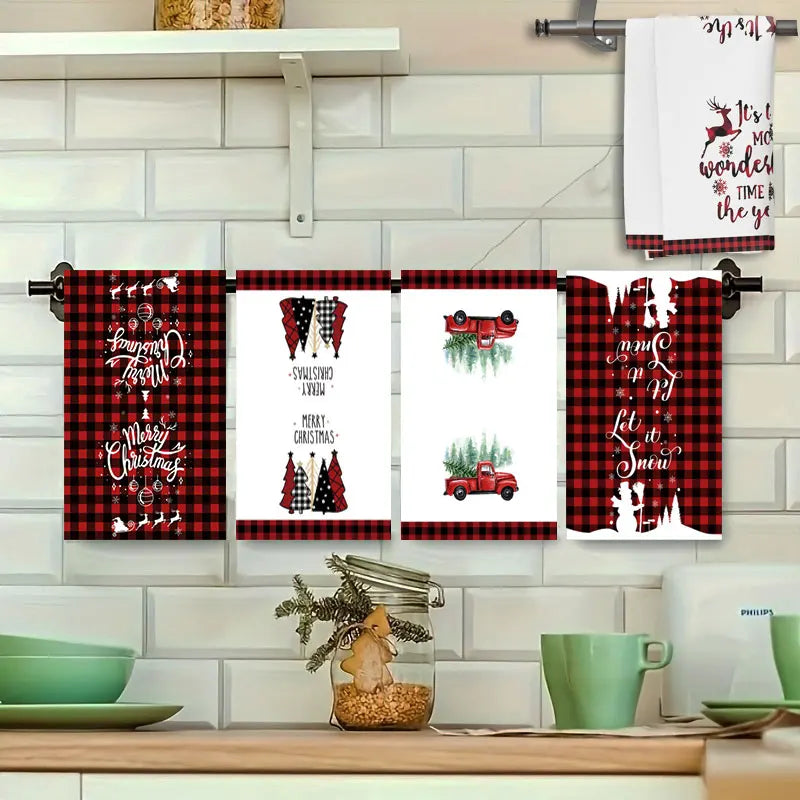 Set of Christmas-themed towels hanging on a rack with a kitchen setting in the background.