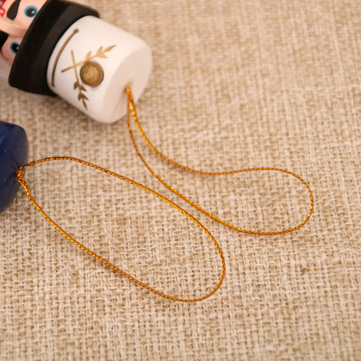 Close-up of a string attached to a toy figure on a textured fabric background