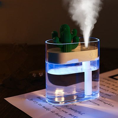 Cactus-shaped humidifier emitting mist on a dark surface