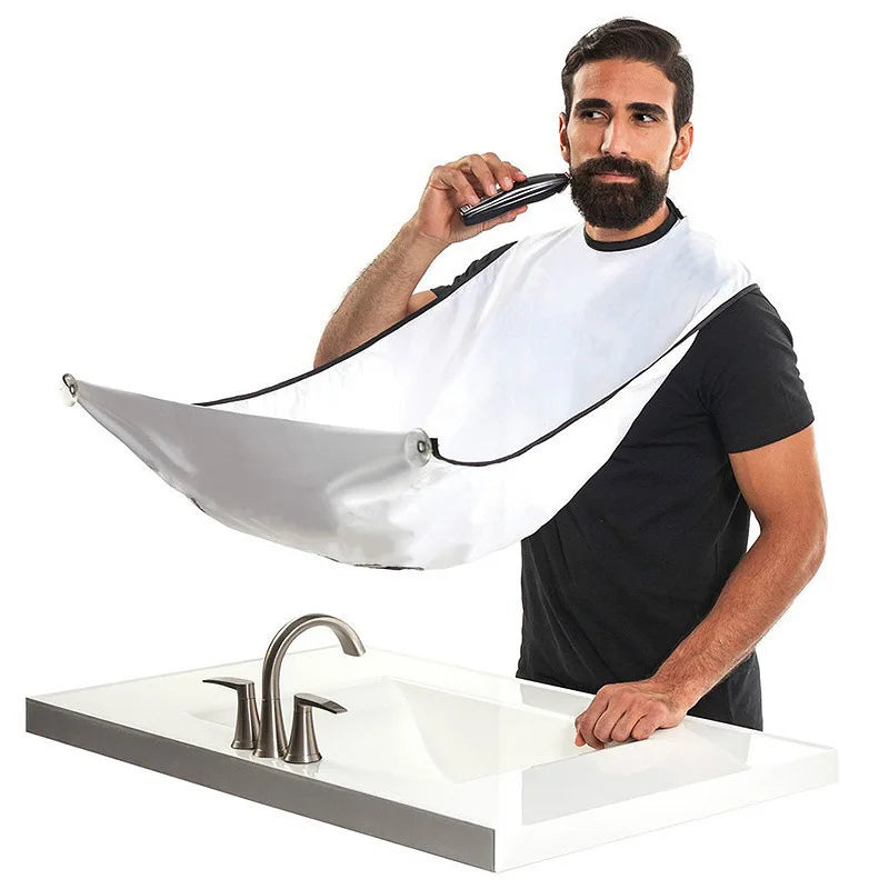 Man using a hair dryer with a white bib over his clothes in front of a sink.