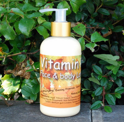 Bottle of Vitamin Face & Body Lotion with a gold pump against a green leafy background