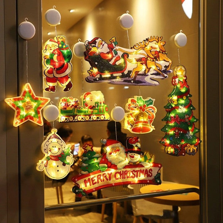 Decorative Christmas lights on a mirror with Santa Claus, reindeer, and other festive elements.