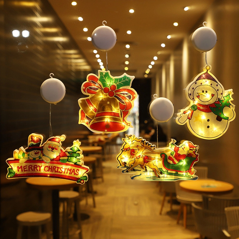 Decorative Christmas lights with a bell, snowman, and Santa Claus in a restaurant setting.